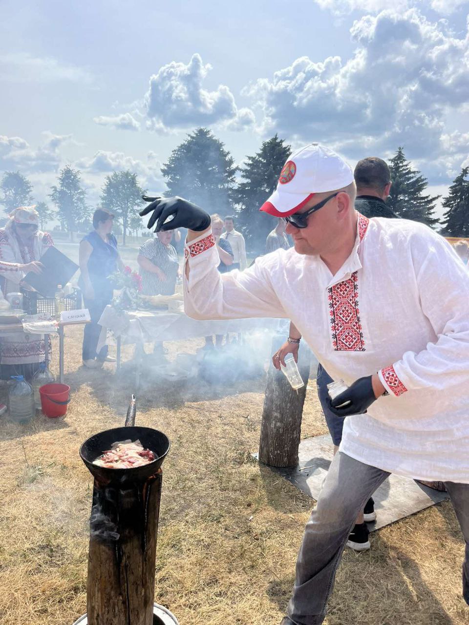 Мужчина что-то готовит на выставке комитета по сельскому хозяйству и продовольствию Миноблисполкома у Кургана Славы в Смолевичах. Фото: twitter.com/BelarusNo