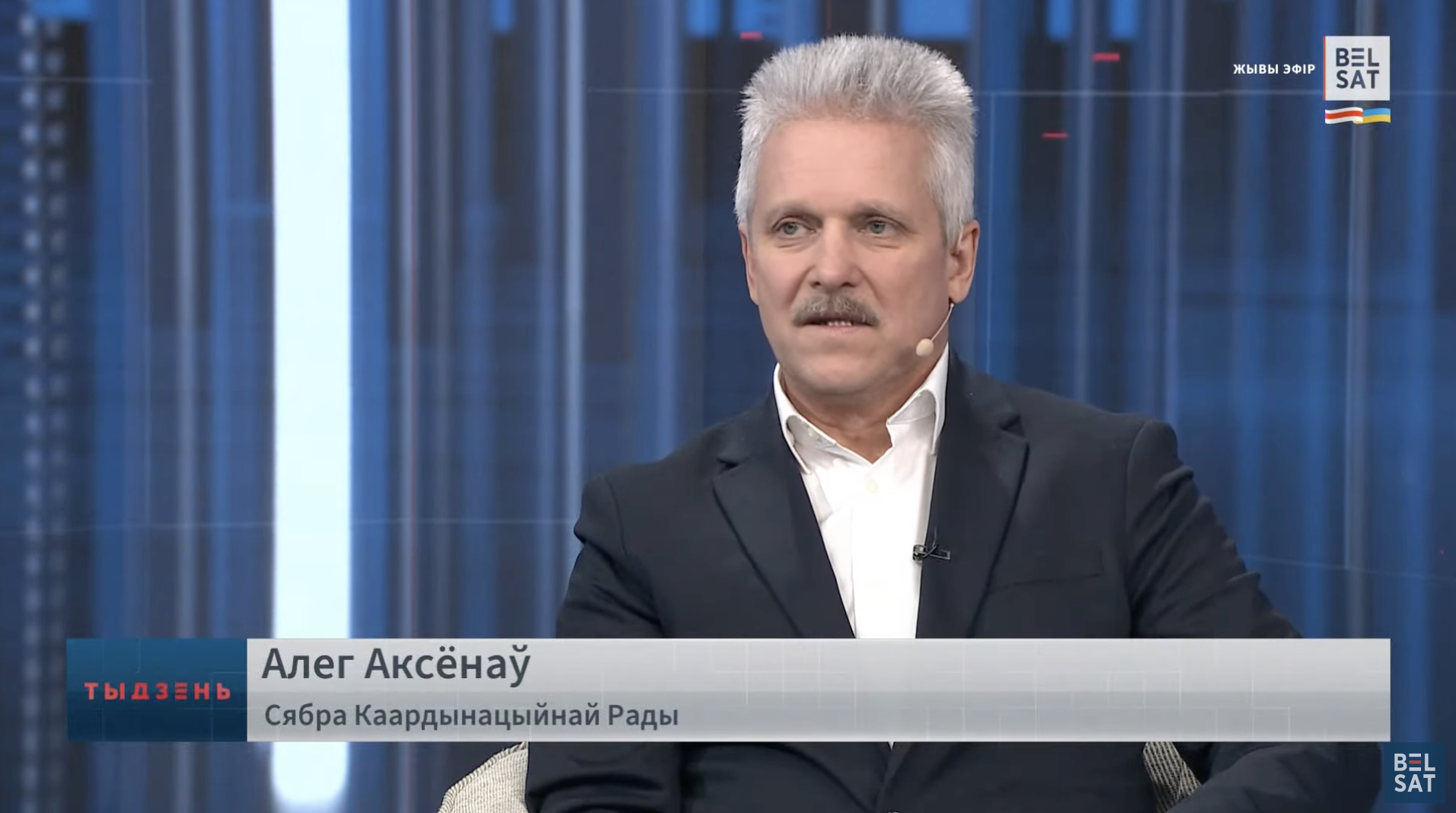 Олег Аксёнов в эфире «Белсат TV» подписан как член Координационного совета, хотя он опроверг это в конце интервью. Скриншот YouTube